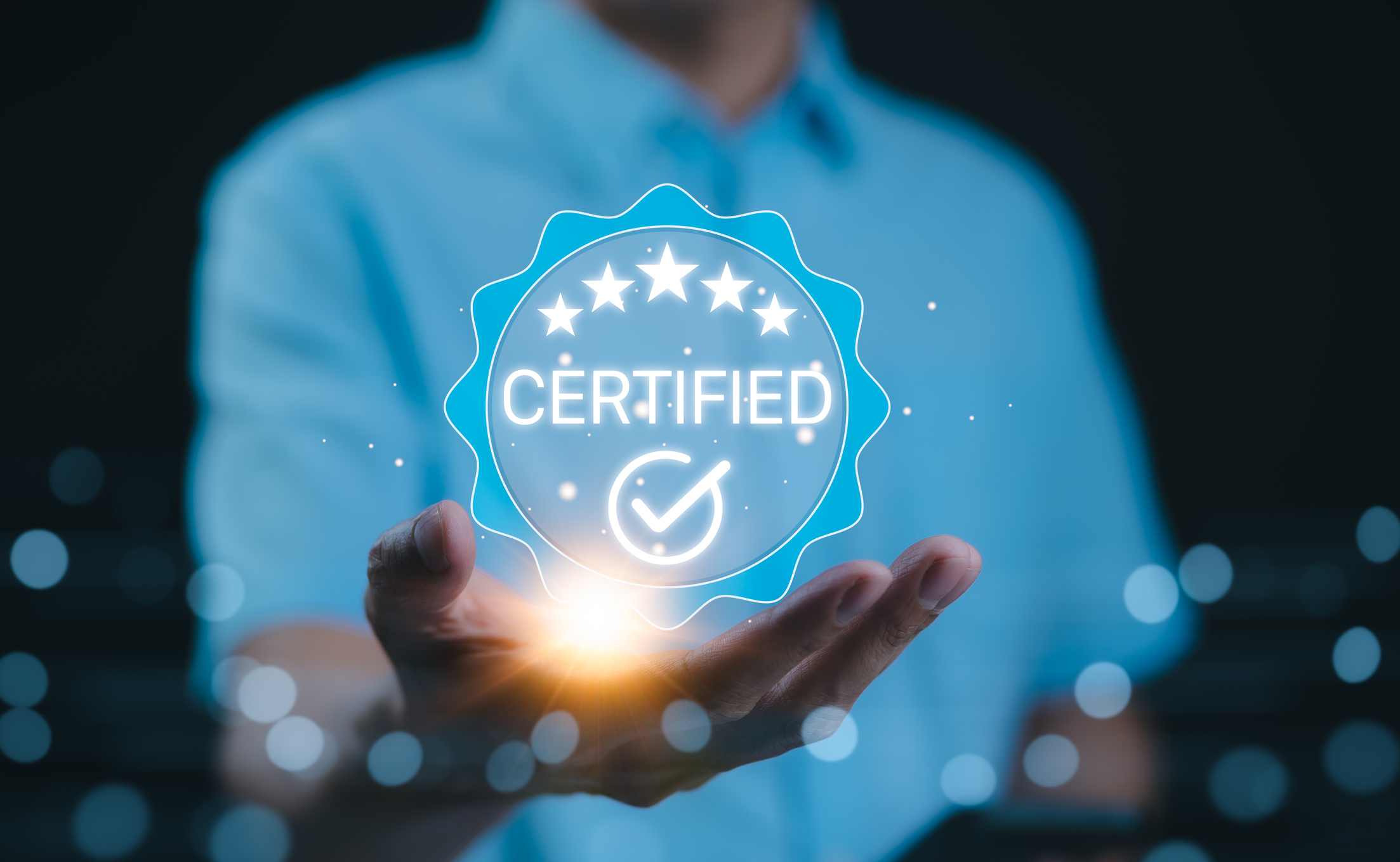 Certified concept. A person holds a glowing holographic badge displaying the word “Certified” with a checkmark and stars, symbolizing quality assurance, accreditation, and validation. ISO Certified, Certified